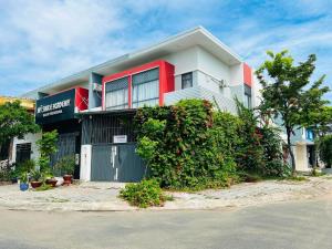 a white and red house with a large bush at KyNa House in Rạch Giá