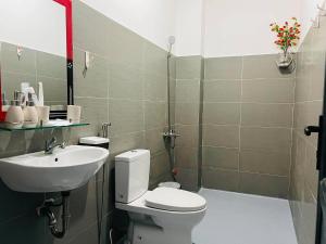 a bathroom with a toilet and a sink at KyNa House in Rạch Giá +6 photos