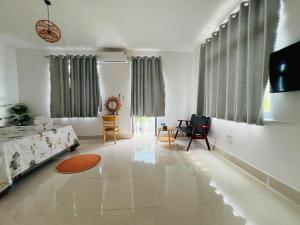 a large white living room with a couch and chairs at KyNa House in Rạch Giá