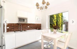 a kitchen with white cabinets and a table and a window at Domino in Dąbrówka