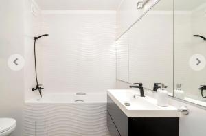 a bathroom with a sink and a tub and a toilet at Domino in Dąbrówka