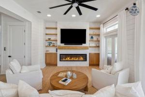a living room with a fireplace and a tv at Beach,Please in Rosemary Beach
