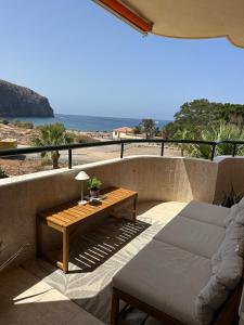 a patio with a couch and a table on a balcony at Costamar Oceanview 1 Bed Apartment in Arona