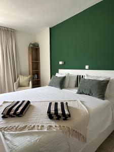 a bedroom with a large white bed with a green wall at Costamar Oceanview 1 Bed Apartment in Arona +8 photos