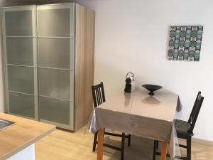 a dining room table with two chairs and a glass cabinet at Au Petit Paradis in Balan