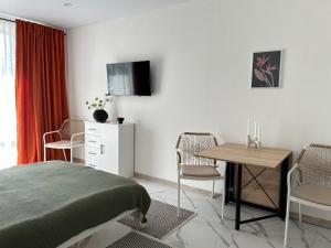 a bedroom with a bed and a table and chairs at Смарт хаус in Yuzhne