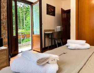 a room with two white towels sitting on a bed at Albergo Ristorante Lo Scoiattolo in Campigna