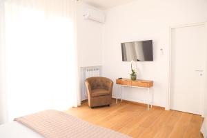 a room with a chair and a desk and a television at Nina Guest house in Gaeta