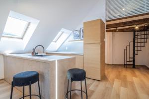 a kitchen with a sink and a counter with stools at Apartmány Ski Telgárt - Telgárt Resort in Telgárt