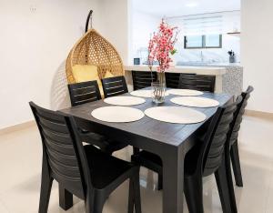 a black dining room table and chairs with flowers on it at Villa Aurora 3 Bedroom 2 Baths in Baños