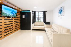 a living room with a couch and a flat screen tv at Villa Aurora 3 Bedroom 2 Baths in Baños