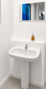 a white sink in a bathroom with a mirror at Villa Aurora 3 Bedroom 2 Baths in Baños +12 photos
