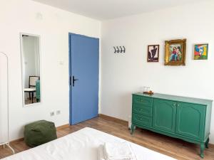 a bedroom with a green dresser and a blue door at Dabfly Guesthouse & Outdoor Adventures in Ražanj
