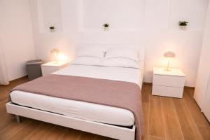a bedroom with a large white bed with two night stands at Nina Guest house in Gaeta