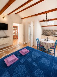 a bedroom with a blue bed with a sink and a table at Studio Apartman Blue Sky in Senj