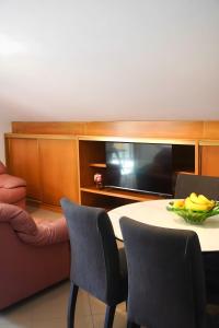 a room with a table and chairs and a television at Casas de São Roque in Vila do Conde