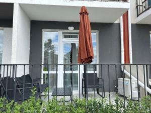 a patio with an umbrella and chairs on a balcony at Смарт хаус in Yuzhne