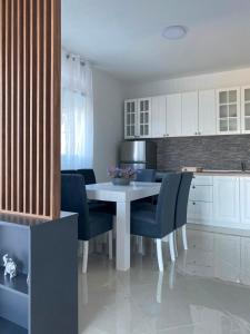 a kitchen with a white table and blue chairs at Vila Marbela in Seoca