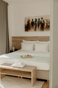 a bedroom with a large white bed with a table at Green Valley Accommodation in Lipovica