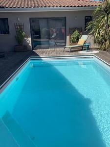 a large blue swimming pool next to a house at Le Studio de Vasconia in Muret