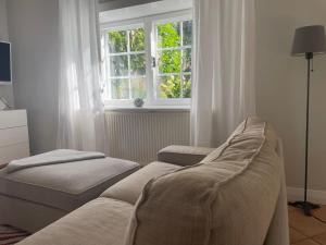 a living room with a couch and a window at Ferienwohnung EINS Hof Himmelgrün in Saal