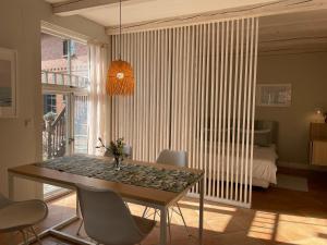 a dining room with a table and chairs and a bedroom at Ferienwohnung EINS Hof Himmelgrün in Saal