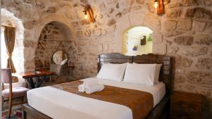 a bedroom with a bed in a stone wall at Mons Masius Hotel Teras in Midyat +240 photos