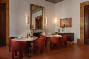 a dining room with two tables and chairs and a fireplace at Palazzo Firenze by Baglioni Hotels & Resorts in Florence