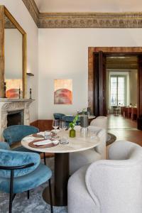 a living room with a table and chairs at Palazzo Firenze by Baglioni Hotels & Resorts in Florence