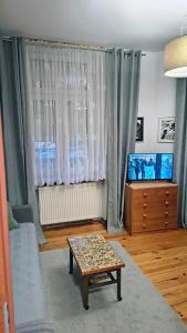 a living room with a table and a window at Chrobry Square - Art Apartament in Gorzów Wielkopolski +2 photos