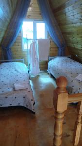 a bedroom with two beds in a wooden cabin at Тайыз Кол in Tossor