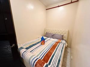 a small bedroom with a bed with a stuffed animal on it at Haku Haven in Baguio