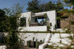 a white house with stairs and plants at Green Valley Accommodation in Lipovica