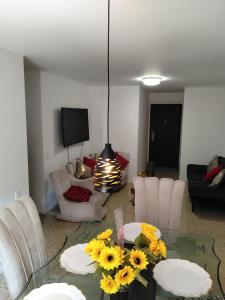 a living room with a glass table with sunflowers on it at We Rent VIP - San Julián in Medellín