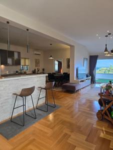 a kitchen and living room with a counter and chairs at Sea View Apartment in Bijela