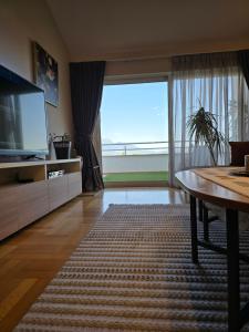 a living room with a large window and a television at Sea View Apartment in Bijela