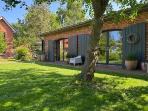 a house with a tree in the yard at Ferienwohnung EINS Hof Himmelgrün in Saal