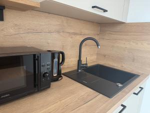a kitchen counter with a sink and a microwave at Penzión Daniel in Ilava +23 photos