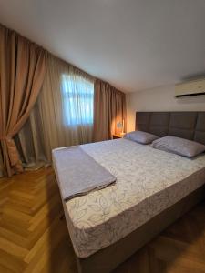 a bedroom with a bed and a window at Sea View Apartment in Bijela