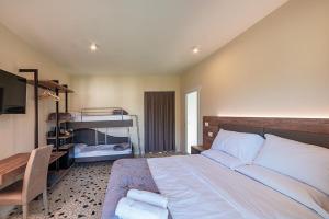 a bedroom with a large bed and a desk at Foresteria Pian di Spagna 2 in Dubino +12 photos