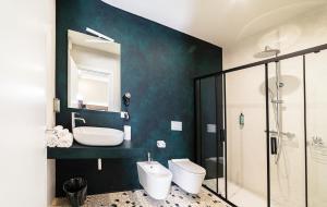 a bathroom with a sink and a toilet and a mirror at Foresteria Pian di Spagna 2 in Dubino