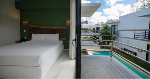 a bedroom with a bed and a balcony with a pool at Luna Azul Bacalar in Bacalar +24 photos