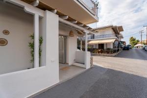 a white building with a door on a street at IOSIF hideaway in Neos Marmaras