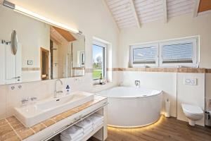 a bathroom with a tub and a toilet and a sink at Luxuswellnesshaus Seepferdchen in Bliesdorf +33 photos