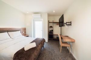 a bedroom with a bed and a desk with a computer at Foresteria Pian di Spagna 2 in Dubino