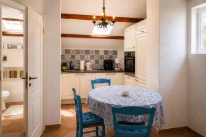 a kitchen with a table and blue chairs in a room at Studio Apartman Blue Sky in Senj
