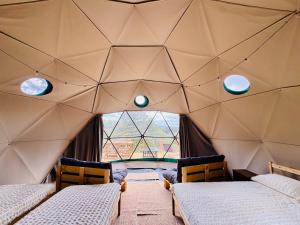 a room with three beds and a large window at Les Coumayres in Riols +101 photos
