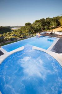 ein großer Pool mit blauem Wasser in der Unterkunft Herdade Do Freixial - Turismo Rural in Vila Nova de Milfontes