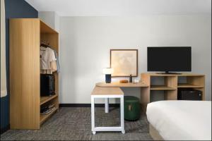 a bedroom with a bed and a desk with a television at Spark by Hilton Clifton in Clifton