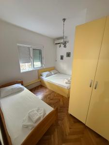 a small room with two beds and a closet at Apartman sa dve spavace sobe, prizemlje, Popović in Petrovac na Moru